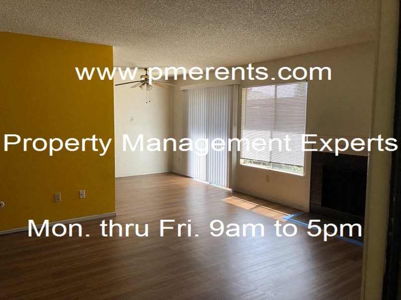 an empty living room with wood floors and a window