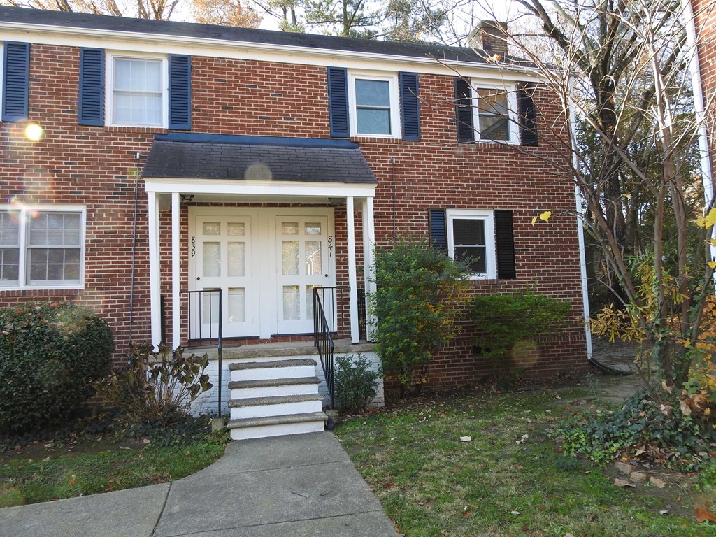the front of a brick house with a white door