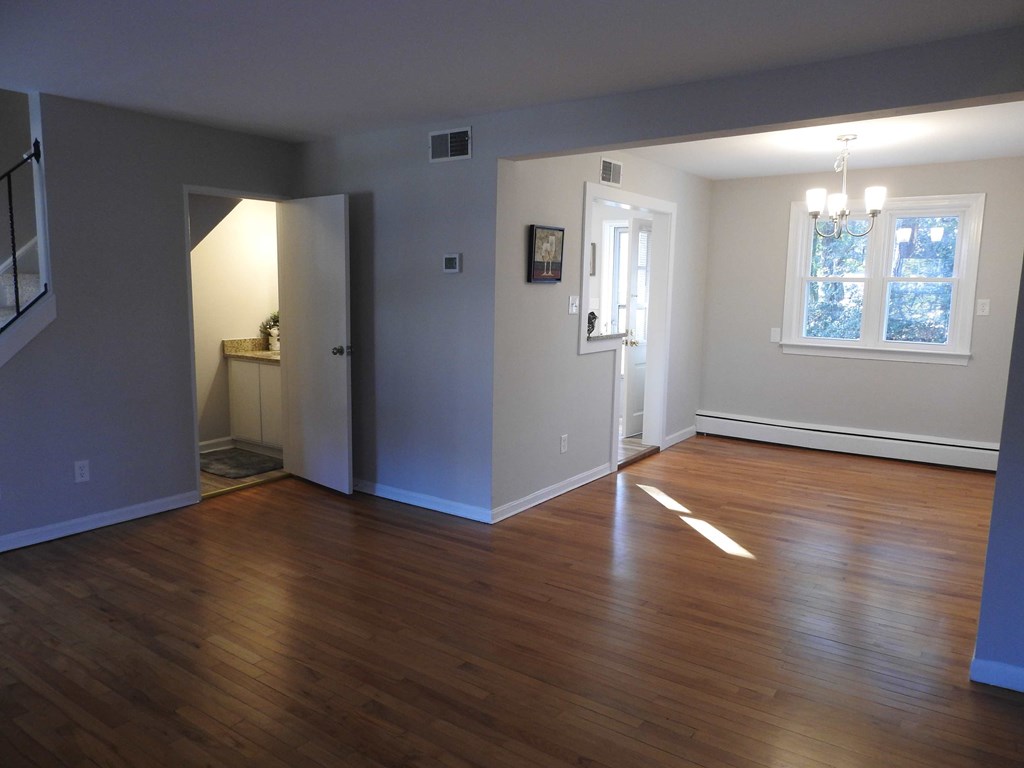an empty living room with a hard wood floor