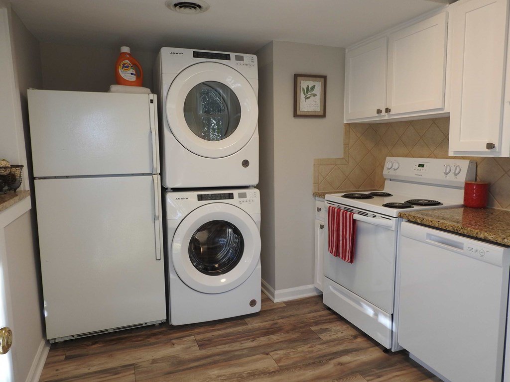 a kitchen with a washing machine and a washer and dryer