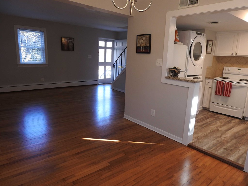 an empty living room with a hard wood floor