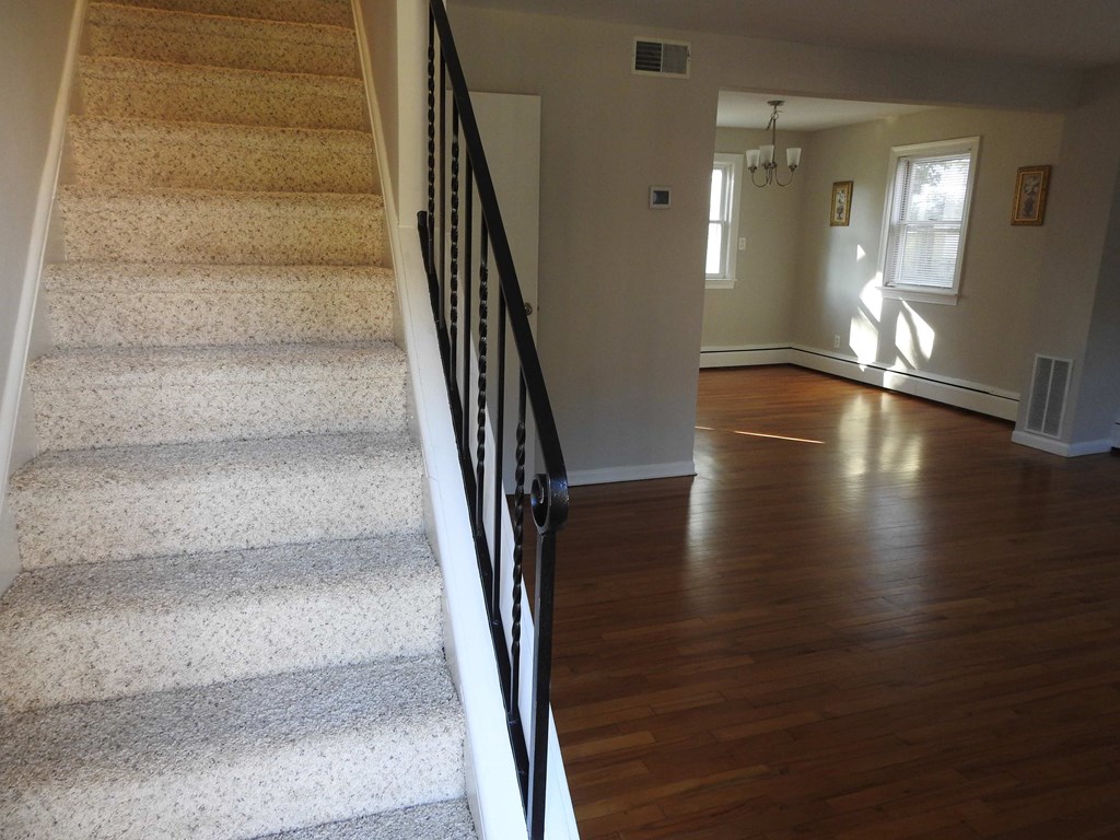 a view from the bottom of the stairs of a house with a hard wood floor