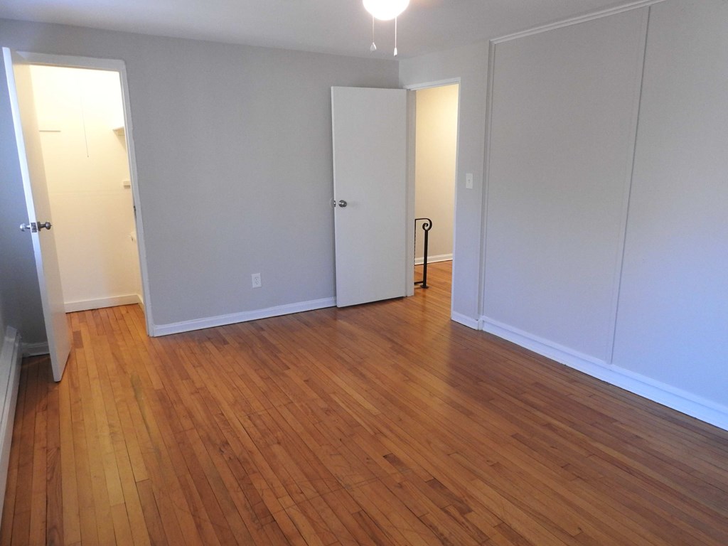 a living room with a hard wood floor and white walls