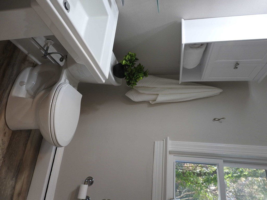 a small bathroom with a toilet and a sink and a window