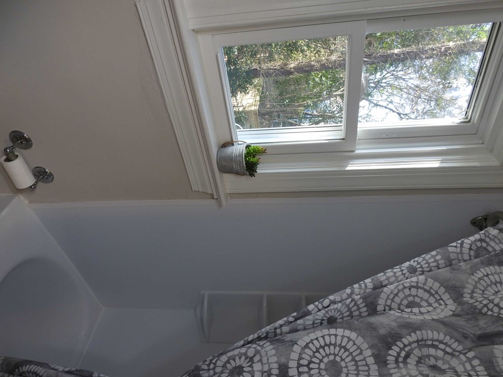a small bathroom with a window above a bed