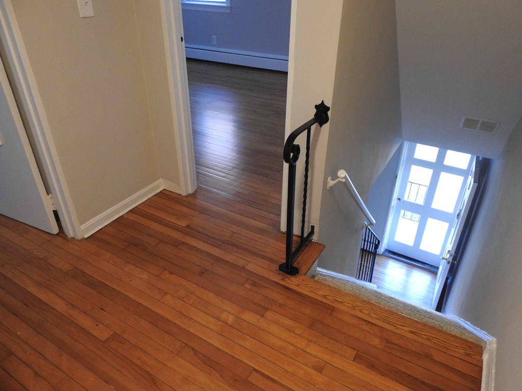 a living room with a hard wood floor and a staircase