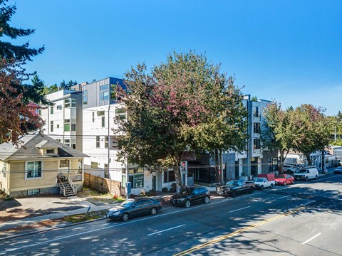 a city street with cars parked in front of an apartment building