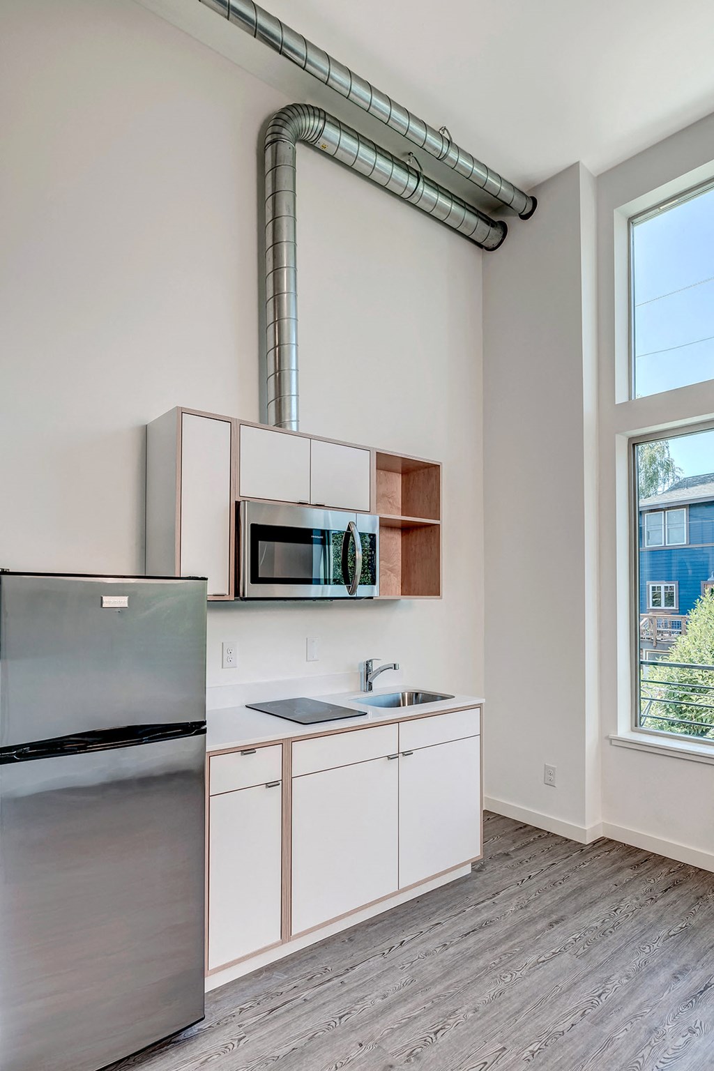 a kitchen with white cabinets and stainless steel appliances and a window