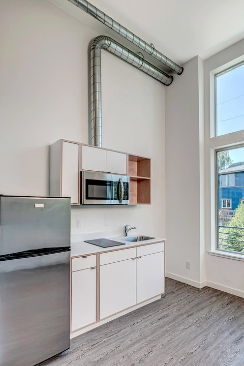 a kitchen with white cabinets and stainless steel appliances and a window