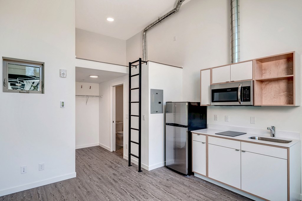 a kitchen with white cabinets and a stainless steel refrigerator