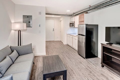 a living room with a couch and a tv and a kitchen