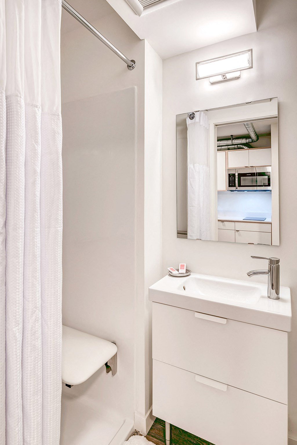 a bathroom with a sink and a mirror and a shower