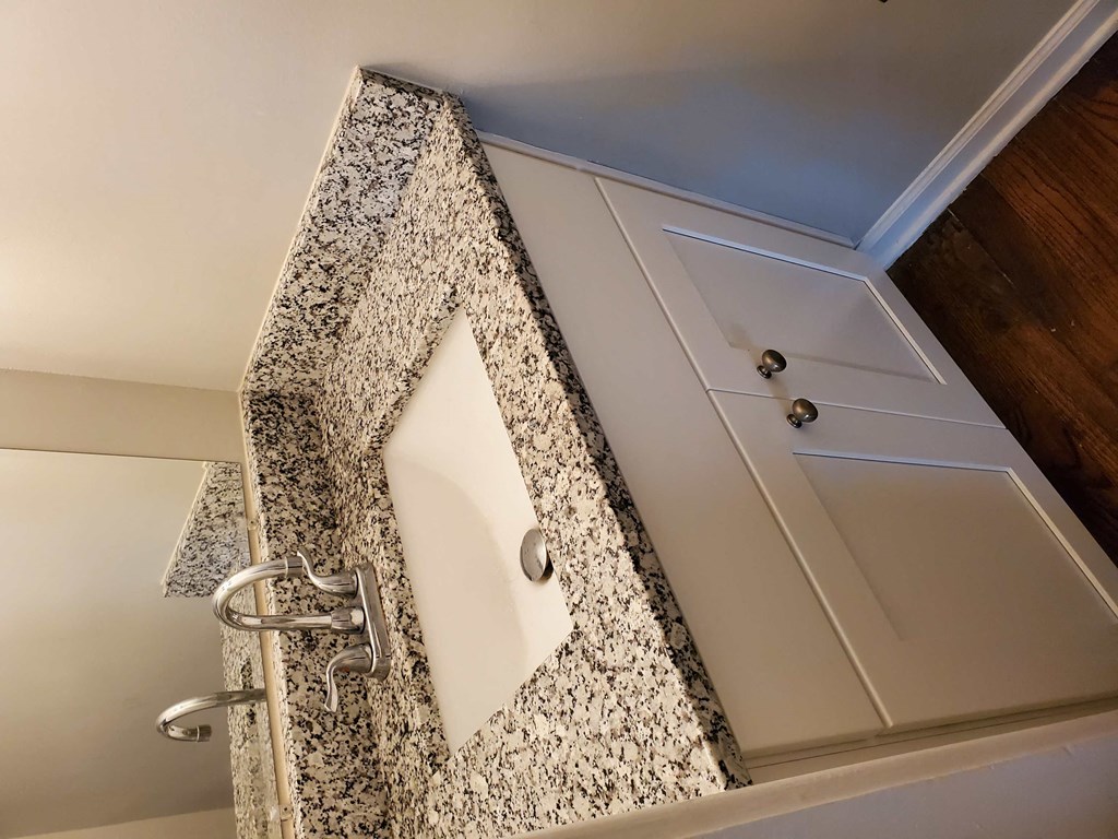a bathroom with a granite counter top and a sink