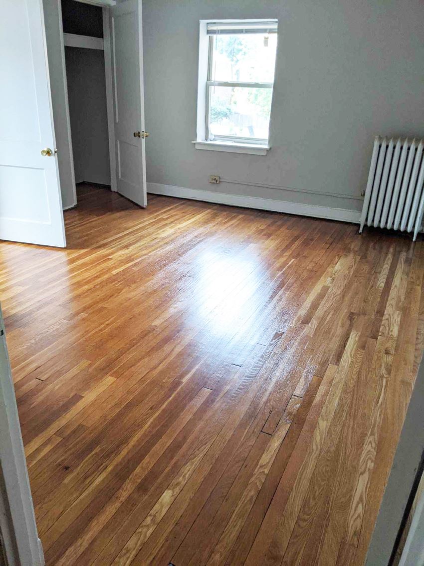 a room with a hard wood floor and a radiator