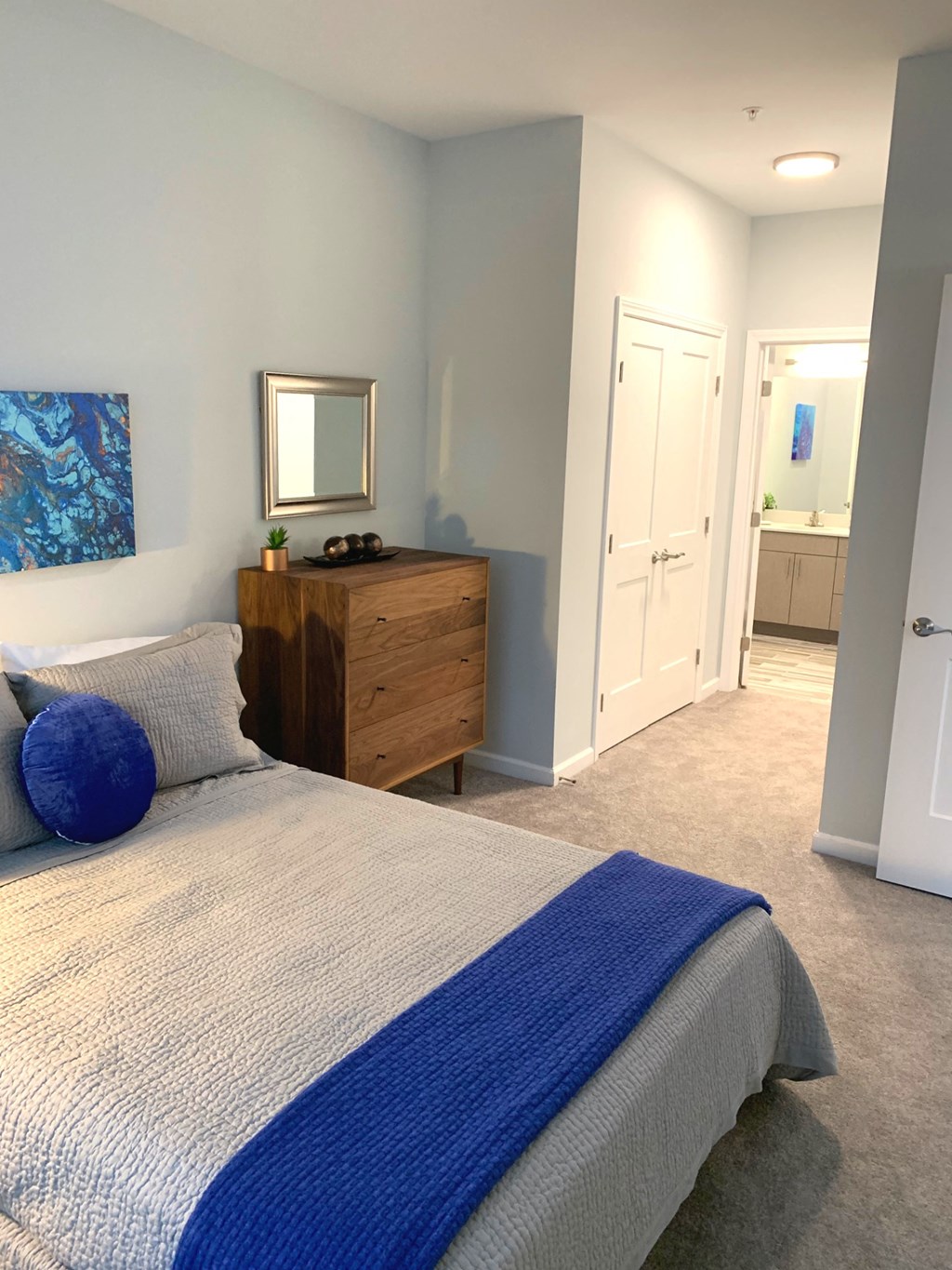 a bedroom with a bed and a dresser and a bathroom