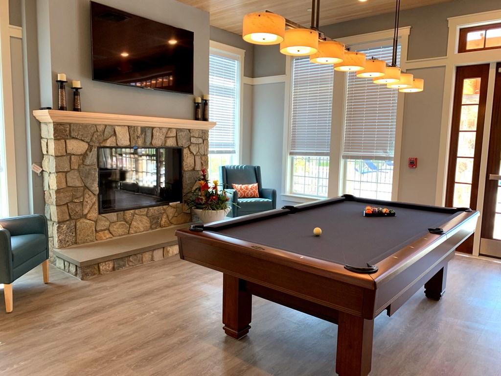 a game room with a pool table and a fireplace