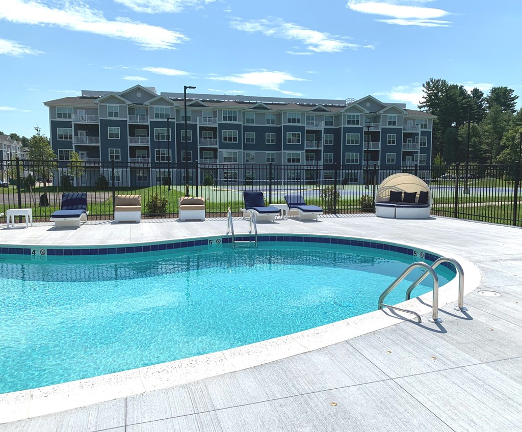 a swimming pool with an apartment building in the background