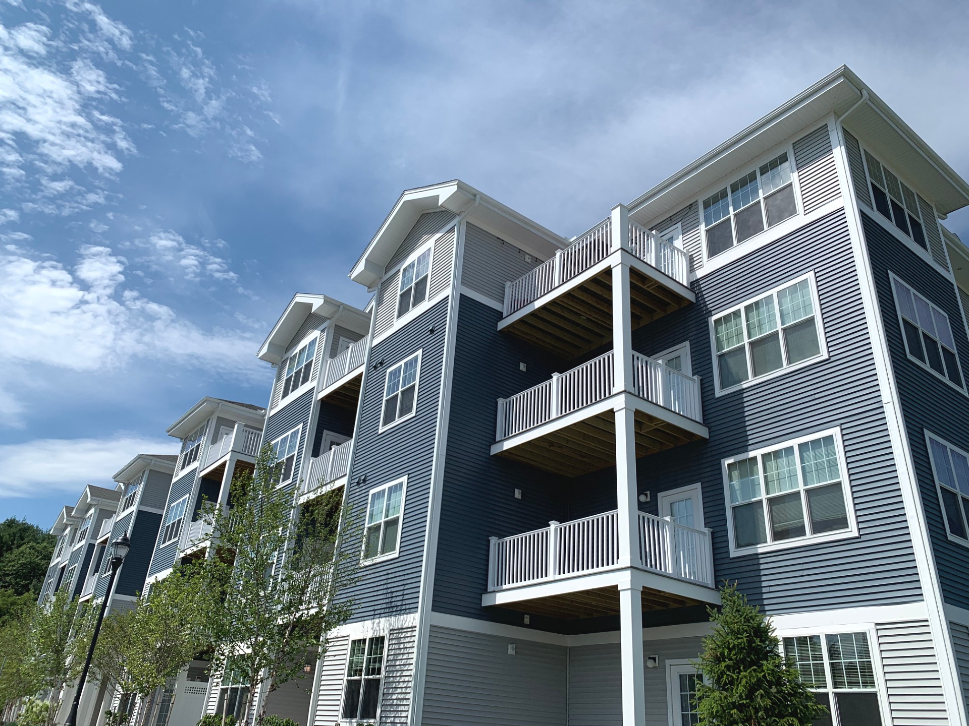 a gray apartment building with balconies and a blue sky
