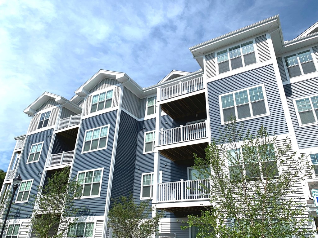 a blue apartment building with trees in front of it