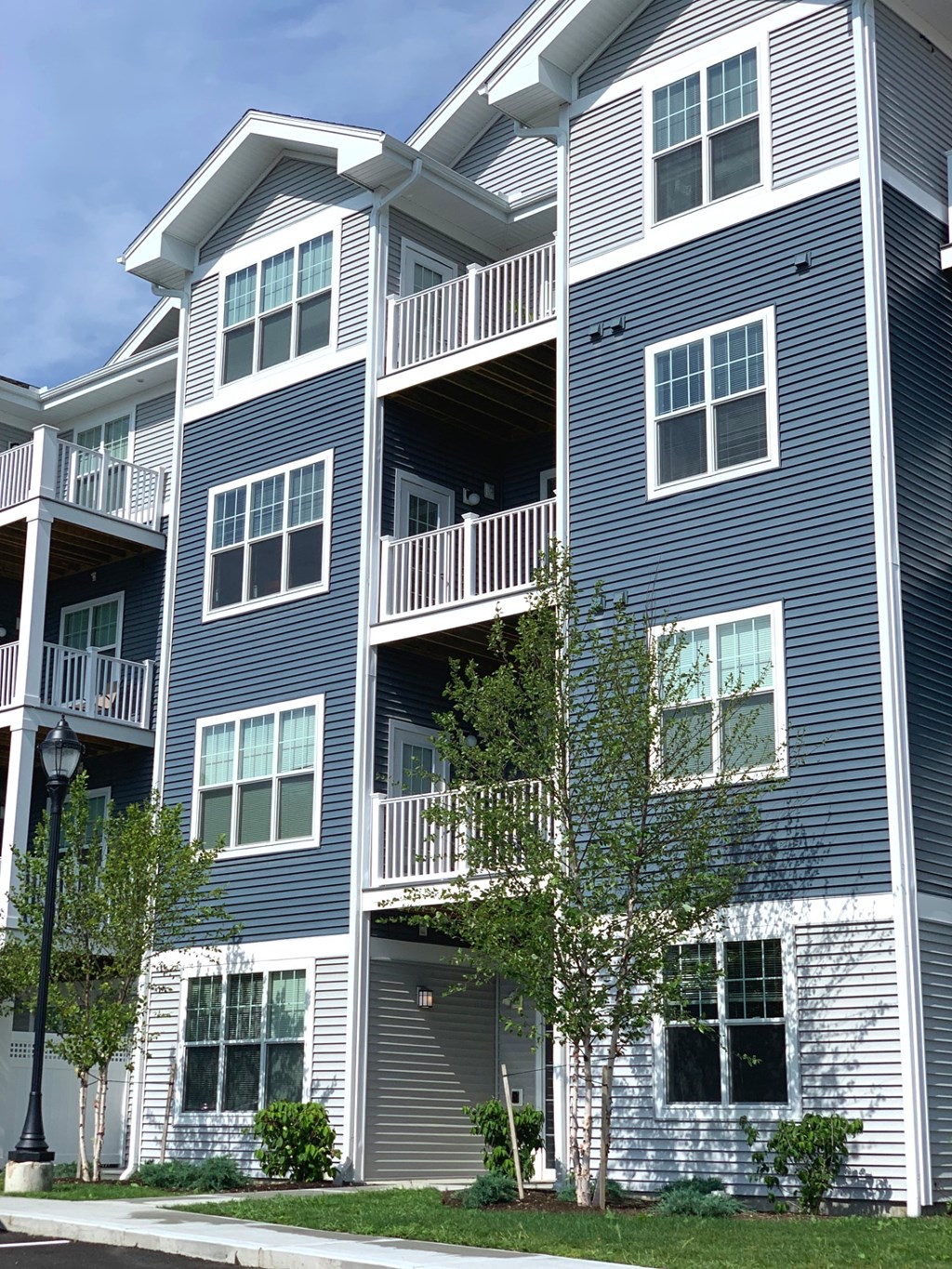 a blue and white apartment building with trees in front of it