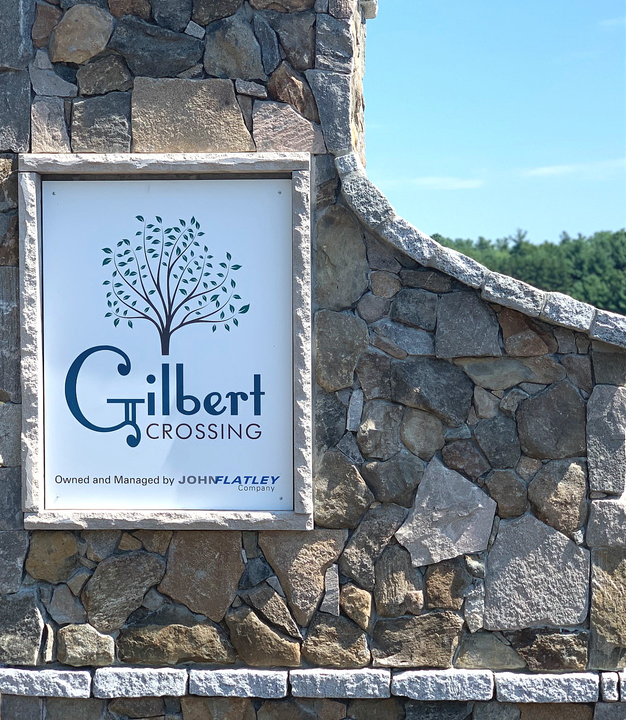 a sign against a stone wall