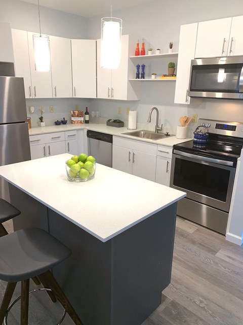 a kitchen with white cabinets and stainless steel appliances and a white counter top