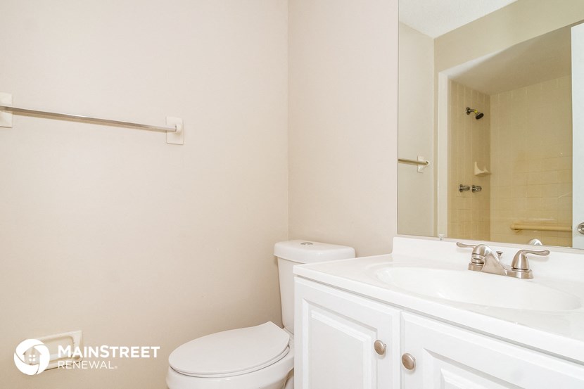 a bathroom with a sink toilet and a mirror