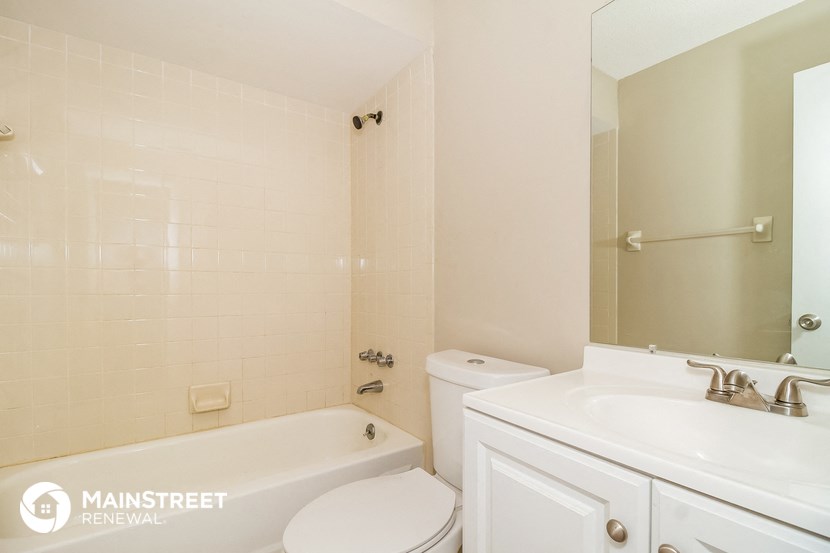 a white bathroom with a tub and a sink and a toilet