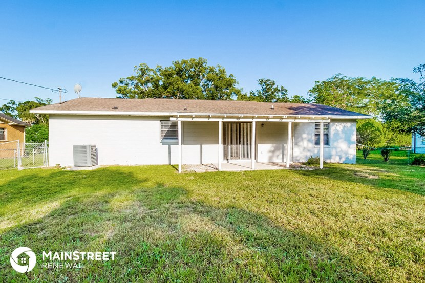 a small white house with a grassy yard in front of it