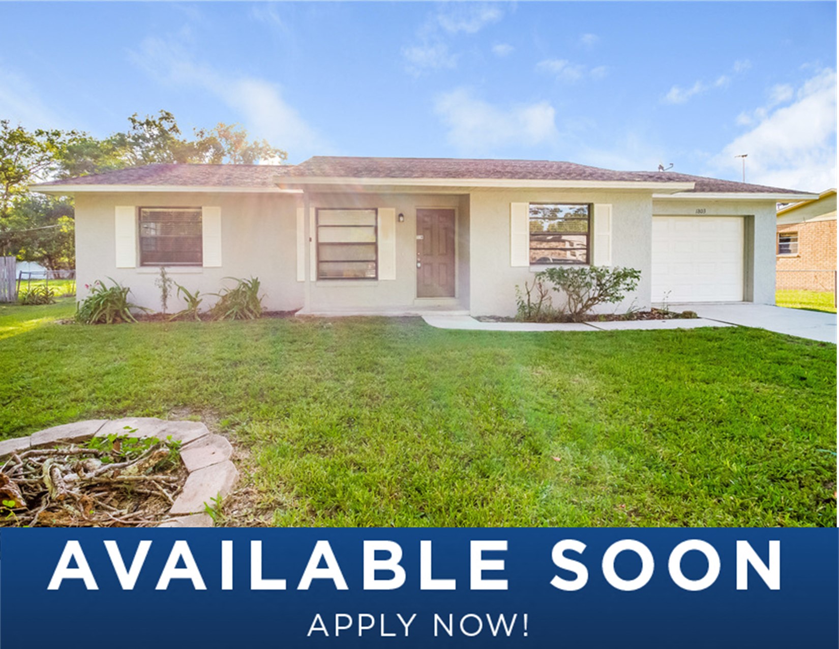 a small white house with a yard and grass