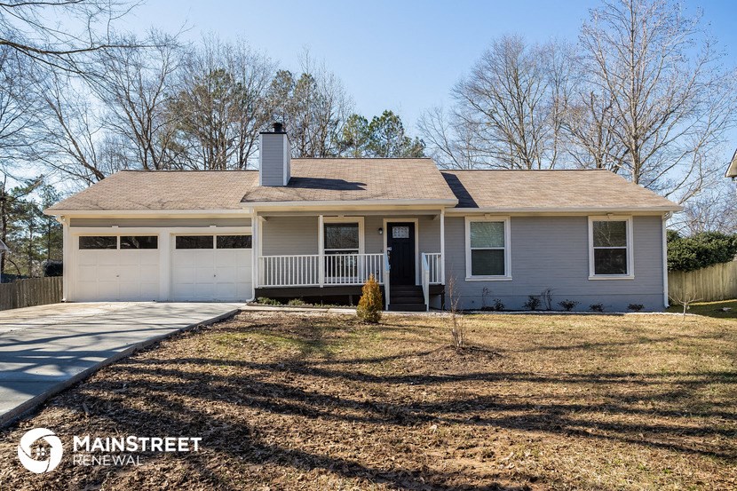 a white house with a front porch and a lawn