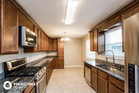a kitchen with wooden cabinets and stainless steel appliances