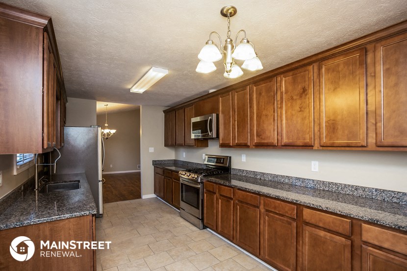 a kitchen with wood cabinets and granite counter tops