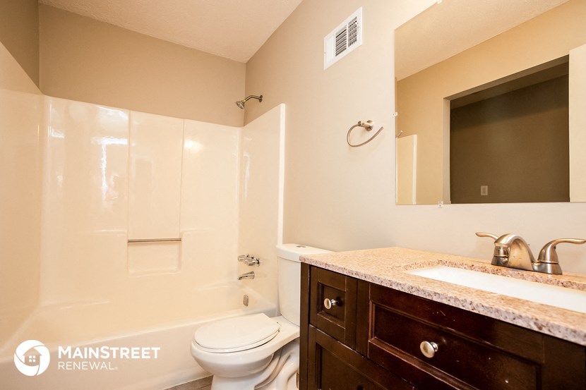 a bathroom with a toilet sink and shower and a mirror
