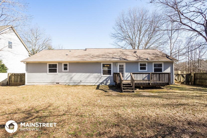 a small white house with a deck and a yard