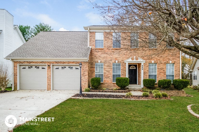 a large brick house with a garage and a lawn