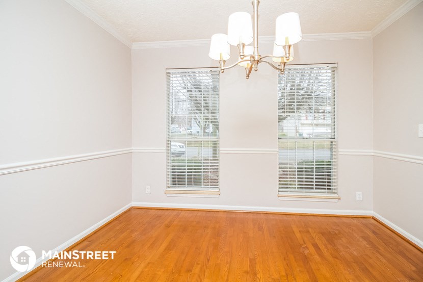 a living room with wood floors and a chandelier