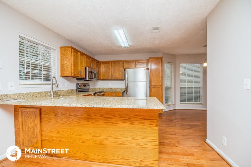 a kitchen with wooden cabinets and a granite counter top