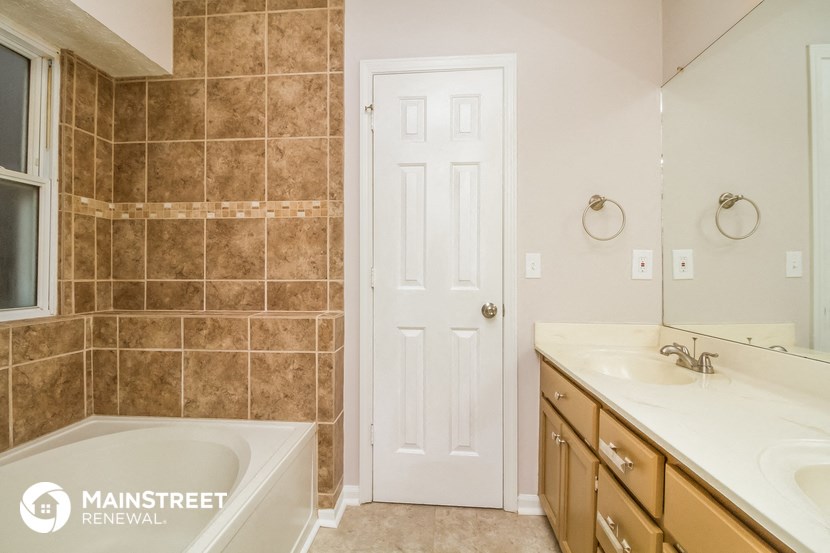 a bathroom with a tub and a sink and a door