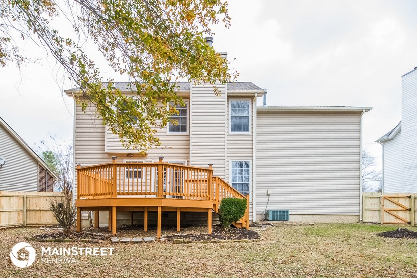 a backyard with a deck and a house