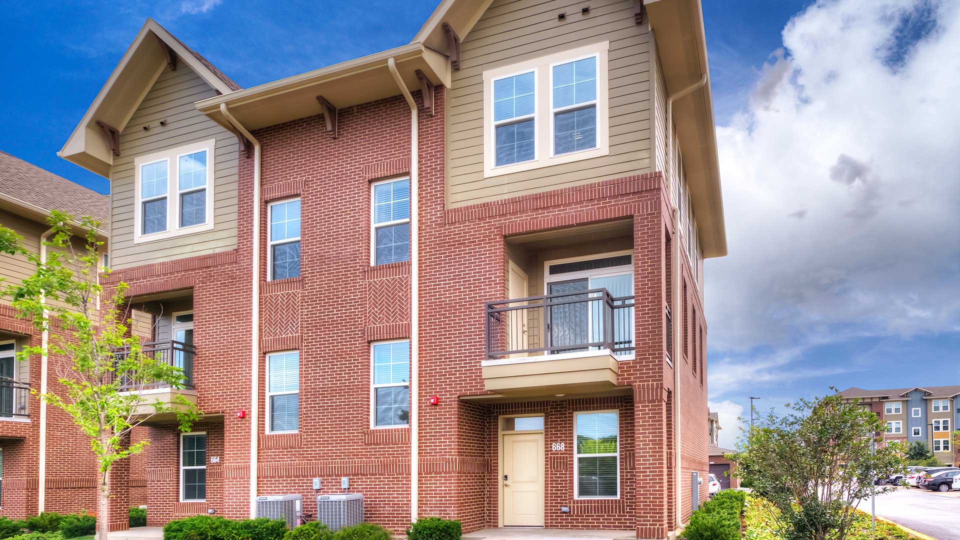 a red brick apartment building with a balcony