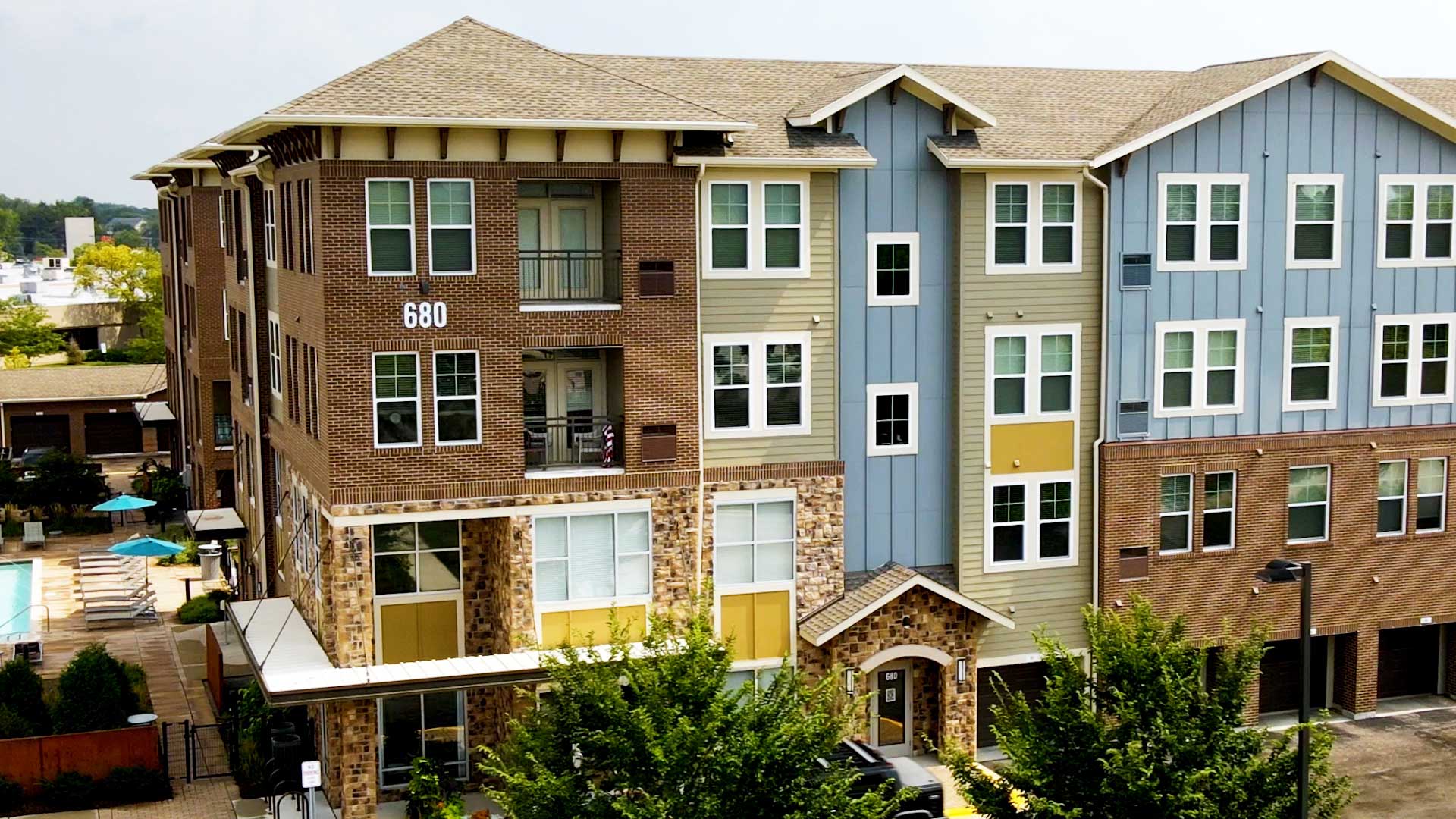 The exterior of the main North 680 apartment building is seen from a drone flying near the top level.