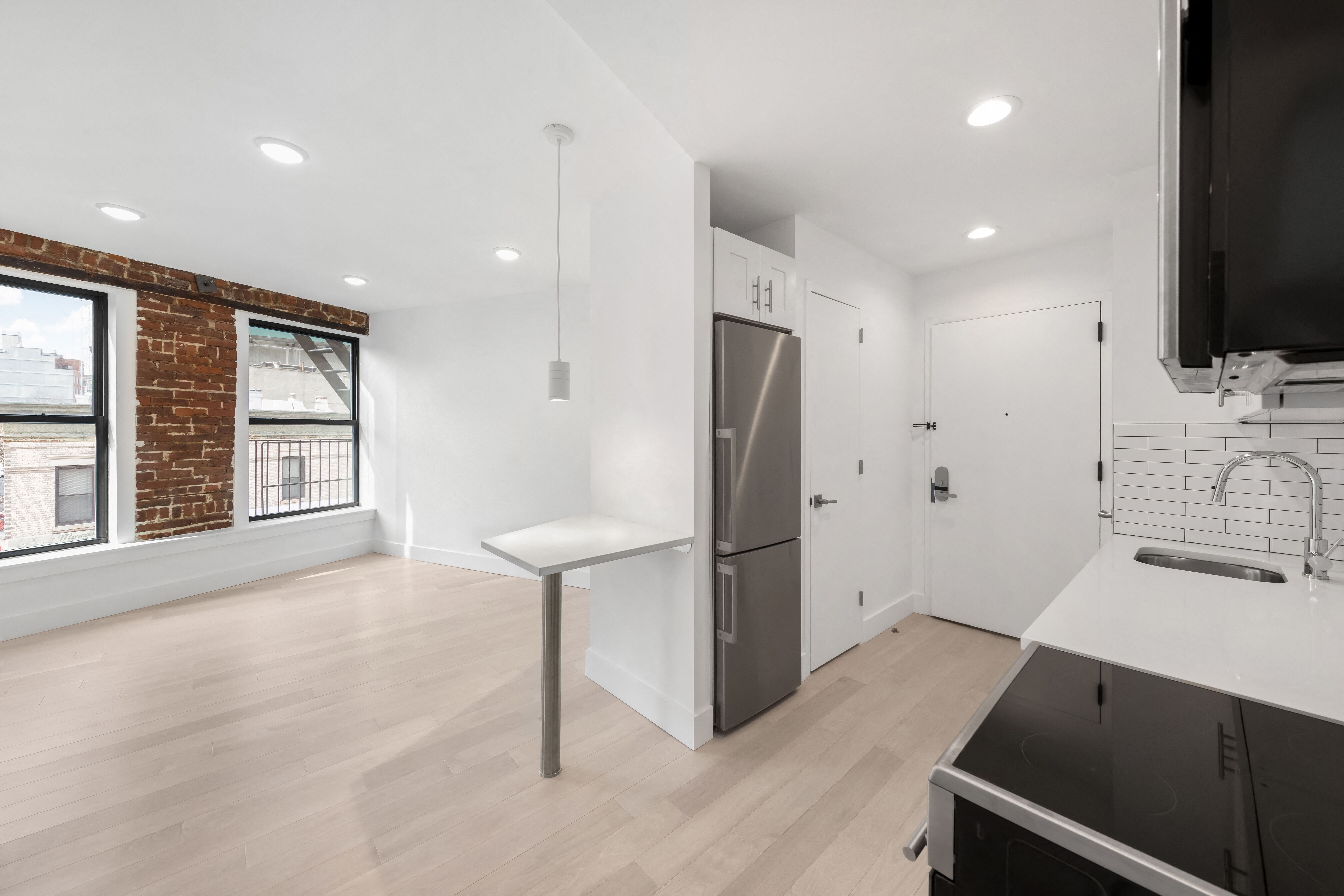 A modern kitchen with a brick wall and a large window.