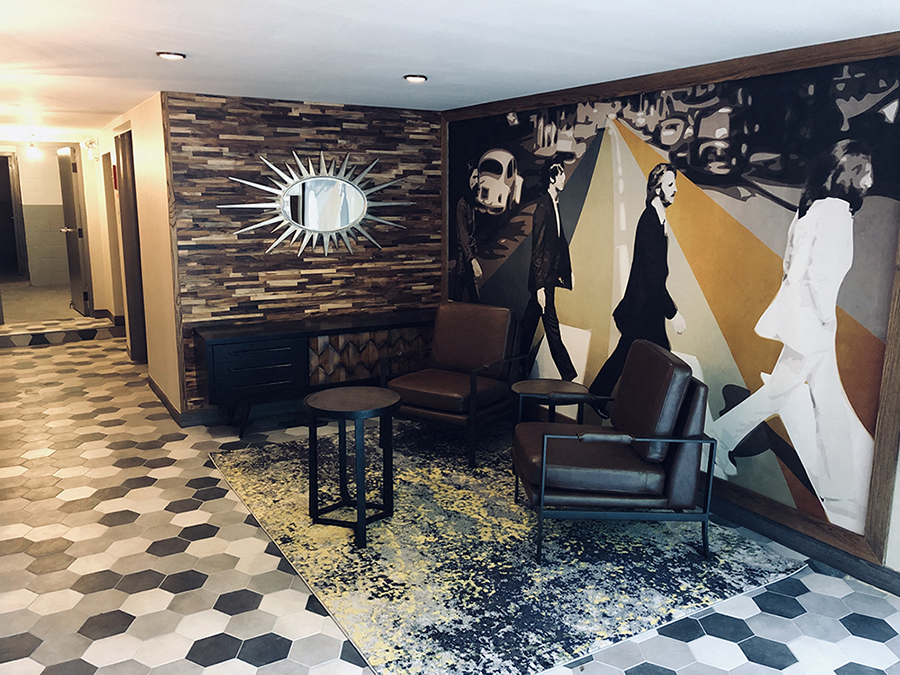 a lobby with chairs and a wall with a mirror