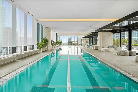 A long rectangular swimming pool in a spacious room.