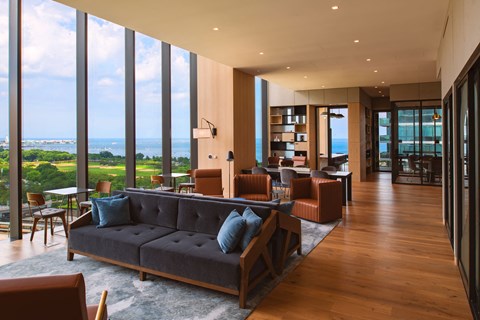A living room with a large couch and a view of the ocean.