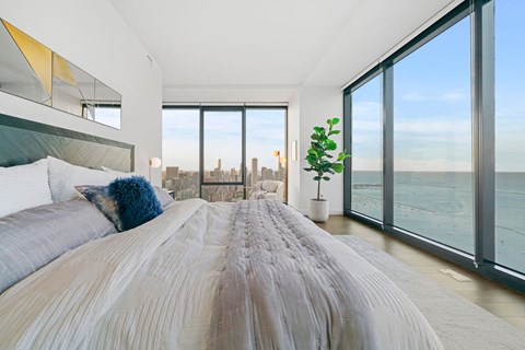 A bedroom with a large bed and a view of the city.