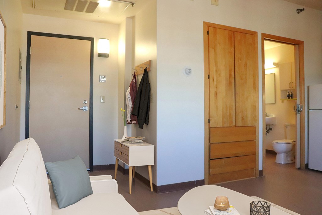 a living room with a couch and a table and a door to a bathroom