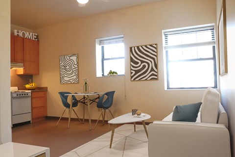a living room with a table and chairs and a kitchen