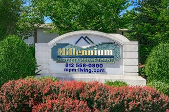 a sign for millenium properties management in front of trees